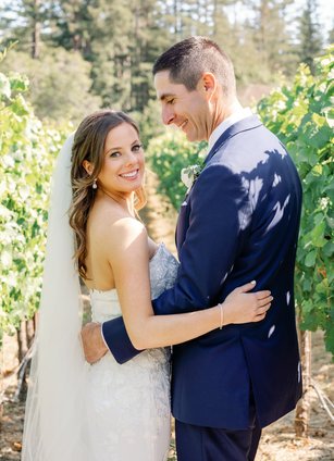 Wedding at a Vineyard in Occidental, Ca. The Bride and Groom and smiling, taking photos in the vineyards. 