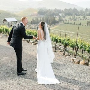 Photographer Hillary Jeanne is perfect at capturing the natural laugh of this wedding couple walking through the vineyards. 