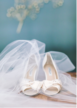 Courtney Stockton Photography captured this bride's wedding veil and wedding shoes perfectly in this Wine Country Wedding at Viansa Sonoma. Placing them in front of the baby blue backdrop was inspired!